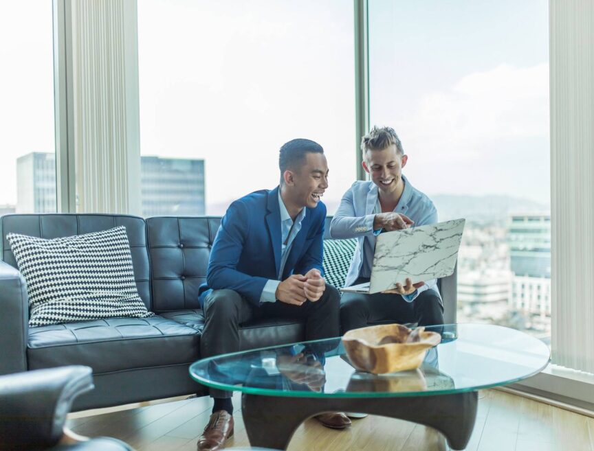 two men in suit sitting on sofa